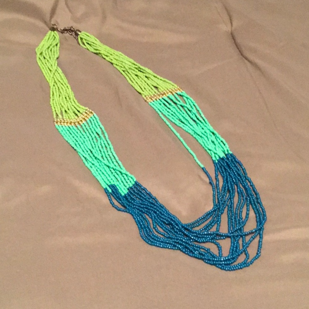 Multi strand tri-color seed bead necklace with gold accent.
